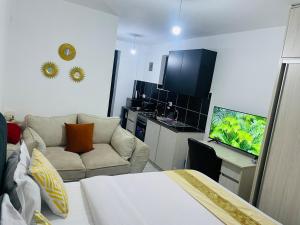 a room with a bed and a couch and a television at Unique by Rose Homes in Nairobi +5 photos