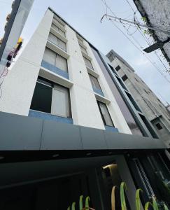 a tall white building with windows on it at Hotel Mauli Lodging in Ahmadnagar