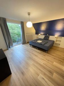 a bedroom with a bed and a wooden floor at Modern 7-Bedroom Villa for Large Families & Groups in Rødby
