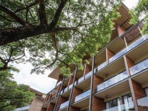 an exterior view of a building with trees at atta Lakeside Resort Suite - SHA Plus Certified in Mu Si