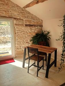 a wooden table and chair in a room with a window at Gite Romantique au coeur du Lot in Crayssac