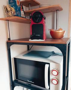 a microwave oven sitting on top of a shelf at Nuit romantique détente et SPA Blagnac Toulouse in Blagnac +23 photos