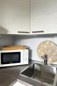 a kitchen counter with a microwave and a sink at Kaksio hyvällä sijainnilla in Kemijärvi