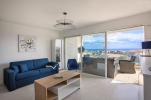 een woonkamer met een blauwe bank en een tafel bij Casa Liblue in LʼÎle-Rousse