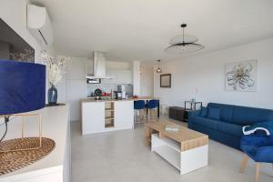 een woonkamer met een blauwe bank en een keuken bij Casa Liblue in LʼÎle-Rousse