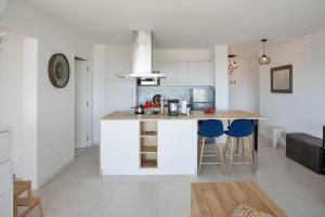 een keuken met een aanrecht en een keukeneiland met krukken bij Casa Liblue in LʼÎle-Rousse +20 foto's