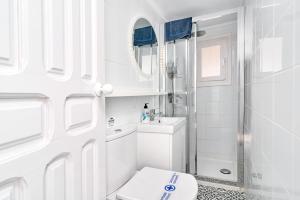 un bagno bianco con wc e doccia di La Casa Bonita a Frigiliana Altre 21 foto