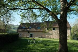 a house with a table and chairs in the yard at Maison Nomade Perche - MaisonNomadeChic in Cour-Maugis-sur-Huisne