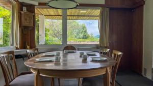 a dining room table with chairs and a large window at Seepanorama Güetital in Faulensee