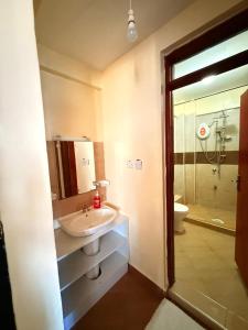 a bathroom with a sink and a shower and a toilet at Zoe Homes-Chic one bedroom near two rivers mall village Marke UN and Embassies along Limuru rd in Ruaka +17 photos