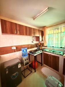 a kitchen with a sink and a table with a water cooler at Zoe Homes-Chic one bedroom near two rivers mall village Marke UN and Embassies along Limuru rd in Ruaka