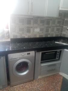 une cuisine avec un lave-linge et un comptoir dans l'établissement Appt, à Zemmour Touirza