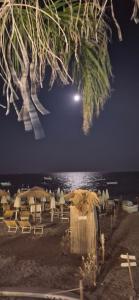 Un grupo de sombrillas y sillas en la playa por la noche. en Casa Travaglianti - Letojanni Taormina, en Letojanni