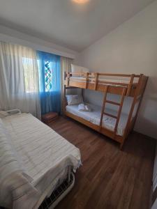 Un dormitorio con dos literas y una ventana. en Lazuli Seafront Beach House Nr18, en Lárnaca