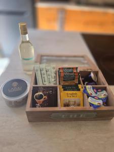Una caja de madera con libros y una botella sobre una mesa. en Lazuli Seafront Beach House Nr18, en Lárnaca