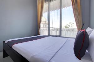 a bed in a room with a large window at Hotel O Guesthouse Sabar Makmur Kledung Syariah in Temanggung +25 photos