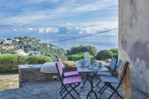 un tavolo e sedie su un patio con vista sull'oceano di Villa A Ventosa a Bastia