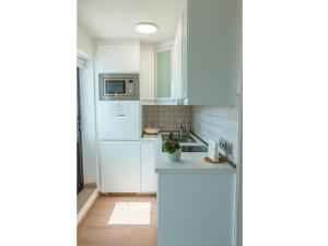 a white kitchen with a sink and a microwave at Mar de Sal in Teguise