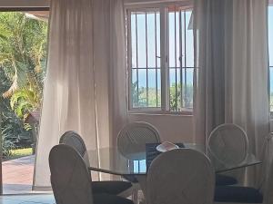 a dining room with a table and chairs and a window at Vervet Guesthouse in Port Edward