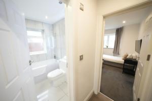 ロンドンにあるHatton apartments HEATHROW AIRPORT- FREE parking-Free underground to and from Heathrow Airport Hatton Cross SEE picture-SEE LONDON fast Hatton cross to central London 30minのトイレと洗面台を備えた白いバスルーム