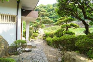 a garden with a stone path next to a house at 内竈ひなた庵 in Kamegawa