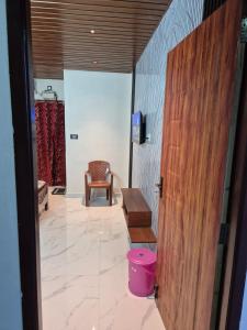 a room with a wooden door and a chair at Sundar Residency Near Annanagar Chennai in Chennai +7 photos