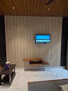 a living room with a television on a wall at Sundar Residency Near Annanagar Chennai in Chennai