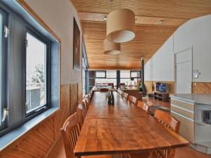 Chalet in Odeigne with Private Pool & Sauna في Manhay: غرفة طعام مع طاولة طويلة وكراسي