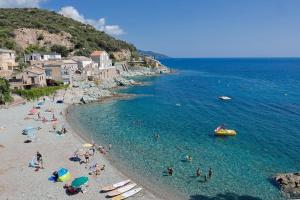a group of people on a beach in the water at Casa Di U Mare in San-Martino-di-Lota