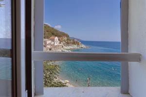 a view of a beach from an open window at Casa Di U Mare in San-Martino-di-Lota