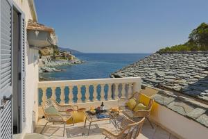 a balcony with chairs and a table and the ocean at Casa Di U Mare in San-Martino-di-Lota