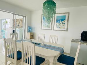 ein weißes Esszimmer mit einem weißen Tisch und Stühlen in der Unterkunft Greek little Getaway - Paros Complex Apartment in Ballito