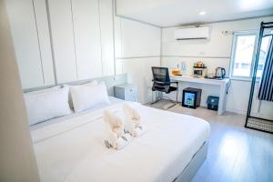 a bedroom with a white bed with two bunny ears at DownTown Hotel in Luang Prabang