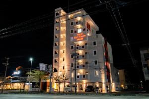 沖縄市にあるHotel Rich Reson AWASEの看板の付いた背の高い白い建物