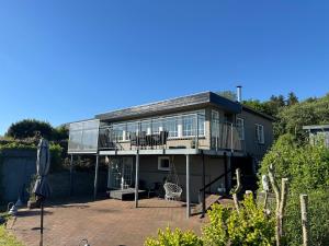 a large house with a balcony and a patio at Beautiful cottage with ocean view in Esbjerg