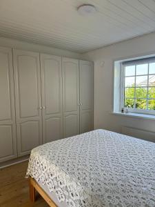 una camera da letto bianca con un letto e una finestra di Beautiful cottage with ocean view a Esbjerg