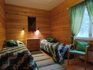due letti in una stanza con pareti in legno di Kuusirinne a Syöte