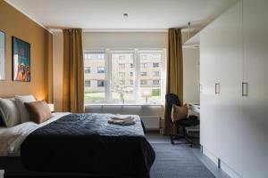 a bedroom with a bed and a desk and a window at Guestly Homes - Nordic Studio in Luleå