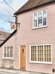 ein rosa Haus mit einem Basketballkorb davor in der Unterkunft Curiosity Cottage in Wendover