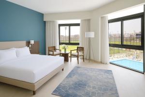 a hotel room with a bed and a table and chairs at Phoenix Hotel & Wellness in Sheikh Zayed