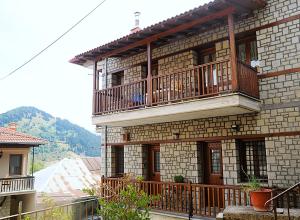 a large brick building with a balcony on it at Κάλλος-Kallos Apartment in Metsovo