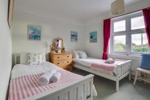 a bedroom with two beds and a window at Millers Cottage in Woodbridge