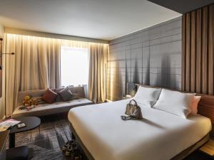 a hotel room with a large bed and a couch at Novotel Cambridge North in Cambridge