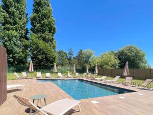 a swimming pool with lounge chairs and a table at ibis Styles Contres-Cheverny in Le Controis En Sologne