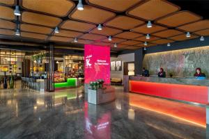 eine Lobby mit einem Restaurant mit einer roten Bank darin in der Unterkunft The K Hotel, WorldHotels Distinctive in Manama