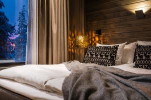 a bedroom with a white bed with pillows and a window at Lapland Hotels Sky Ounasvaara in Rovaniemi +65 photos