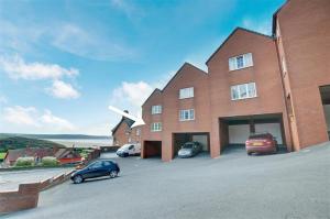 a large brick building with cars parked in front of it at The Beach Snug in Woolacombe