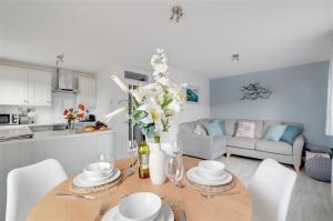 a kitchen and living room with a table and chairs at The Beach Snug in Woolacombe