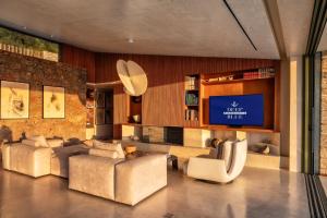 a living room with couches and a flat screen tv at Villa Deep Blue in Messinia in Verga Kalamata