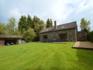 a stone house with a large lawn in front of it at Elegant Bevercé Escape in Malmedy